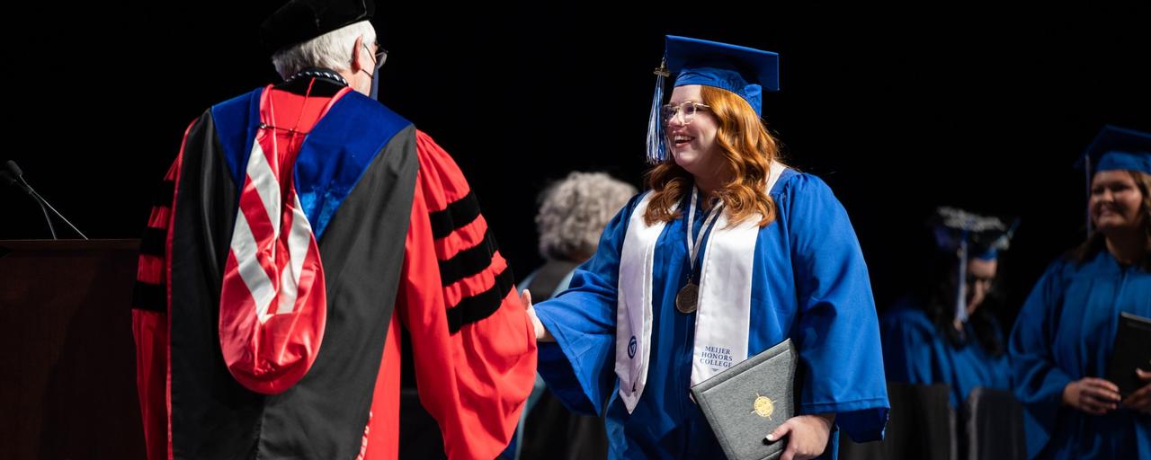 Honors student shaking hands at commencement